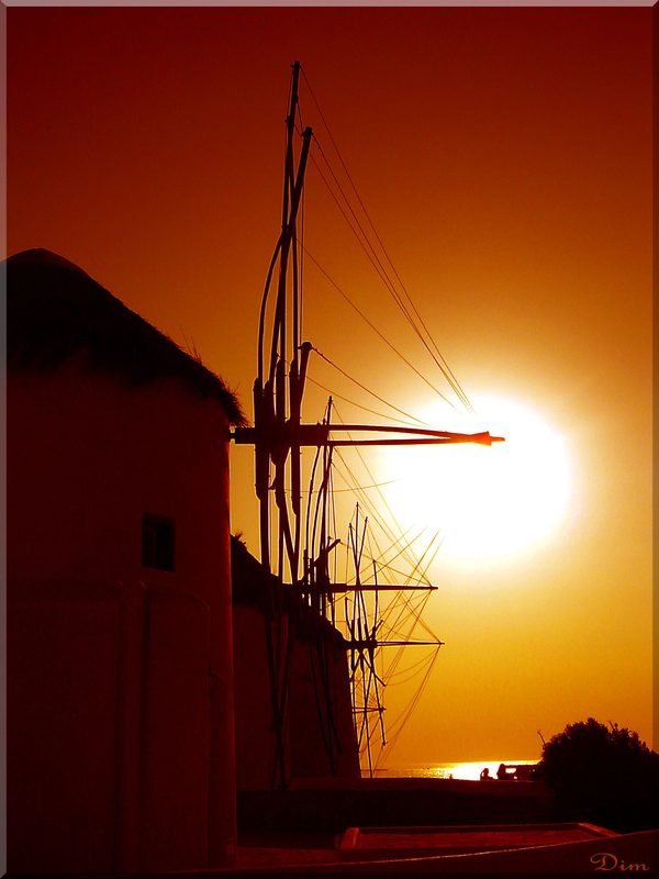 The iconic windmills of Mykonos town against a blue sky