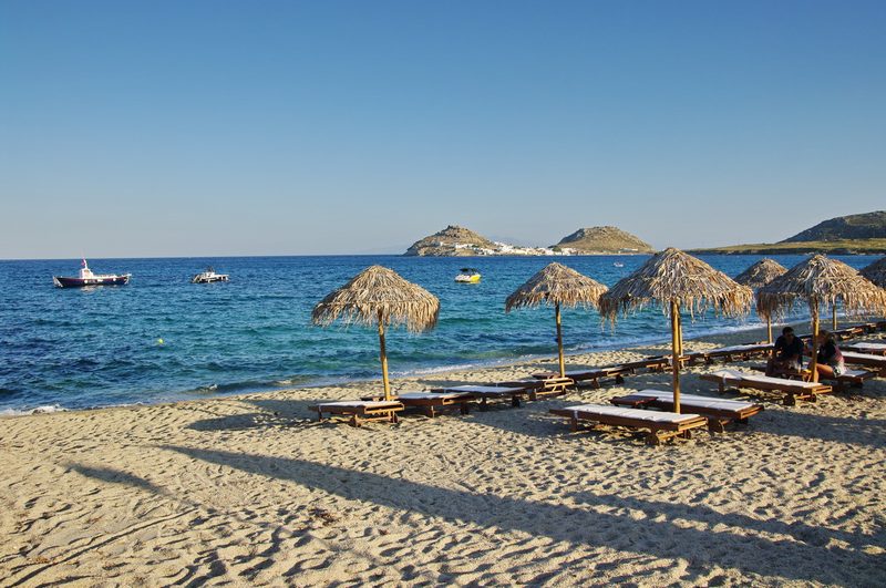 A sandy beach with hills resembling "Aphrodite's Breasts" in the background at Kalafatis Beach, Mykonos.