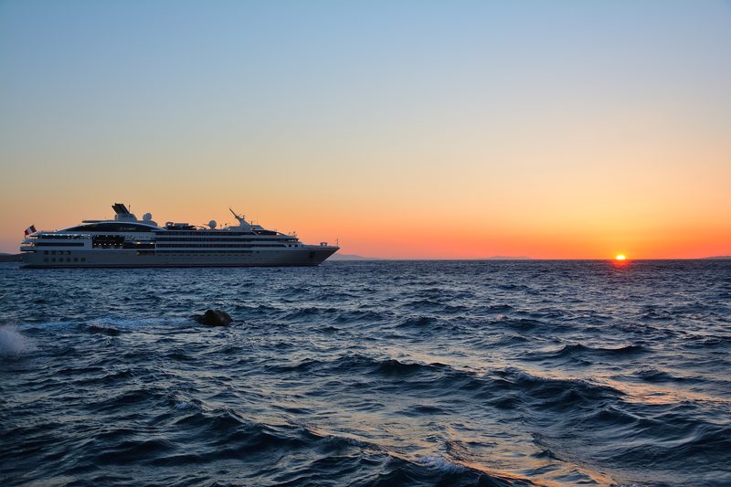 A luxurious cruise ship docked at a picturesque port in Mykonos.