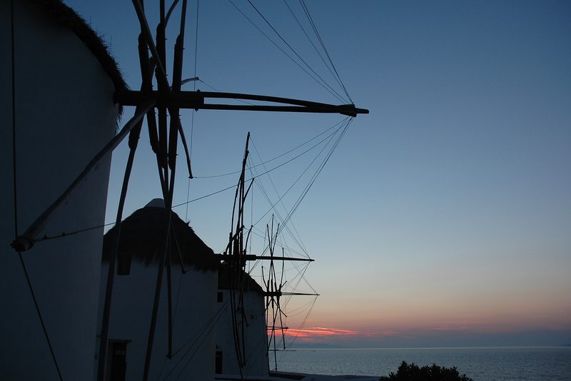 A picturesque street in Mykonos, Greece, lined with whitewashed buildings and vibrant bougainvillea.