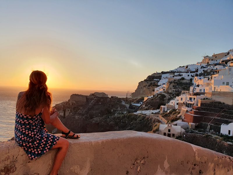 Watching the sun set over the Santorini caldera, with the white clifftop village glowing in the evening light