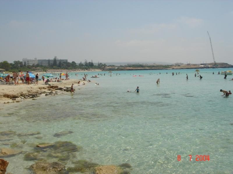 A picturesque beach scene in Mykonos with a family enjoying the sun and sea.
