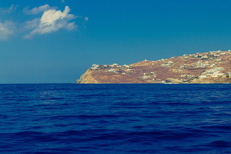Ruins of ancient buildings scattered across the rocky terrain of Delos Island.