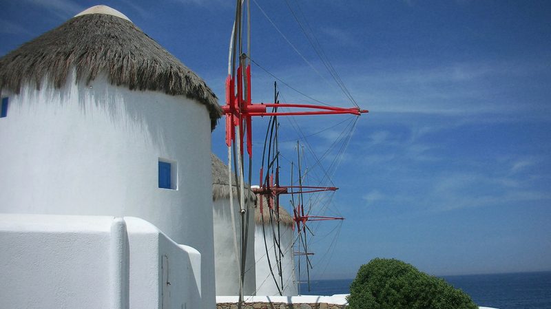 A vibrant beach scene at Paradise Beach on Mykonos Island, with people enjoying the sun and sea.