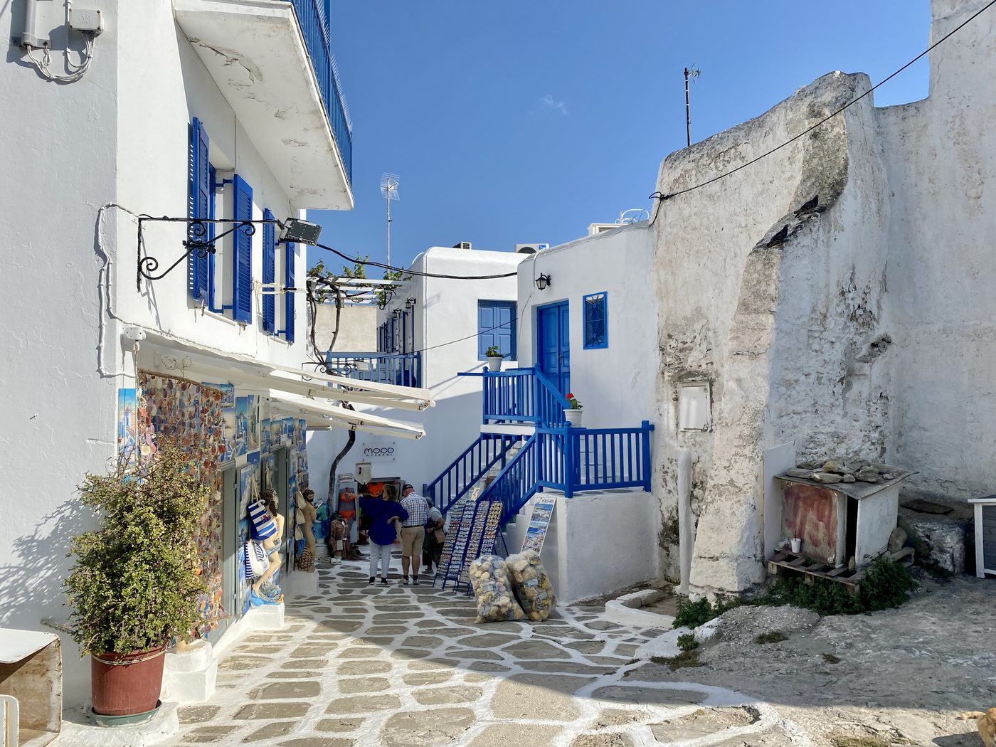 A quiet street in Mykonos with whitewashed walls and blue shutters
