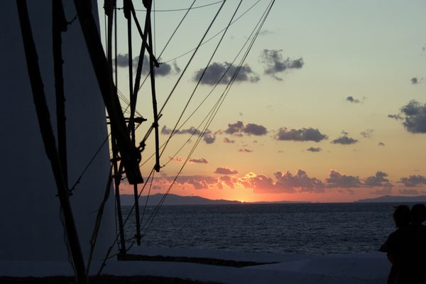 Sunset over the windmills of Mykonos with the sea beyond