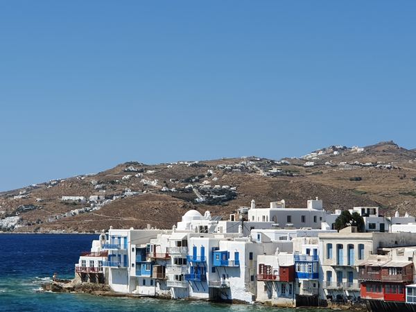 Little Venice waterfront houses at the edge of Mykonos Town with the bare hillside behind